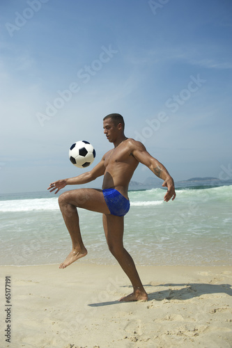 Athletic Young Brazilian Man Kicking Football Beach photo