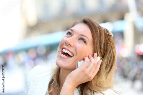 Portrait of blond woman laughing on the phone photo