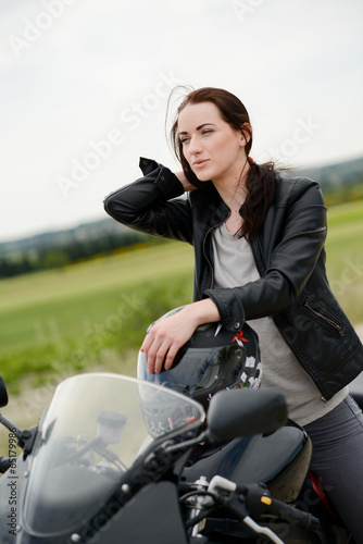 cheerful and beautiful young woman riding motorbike