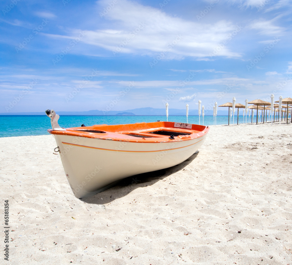 Umbrellas and a boat on a beautiful  sandy beach