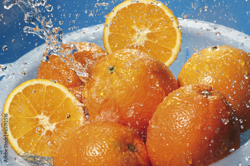 Fototapeta Naklejka Na Ścianę i Meble -  Spritzwasser auf frische Orangen im Sieb