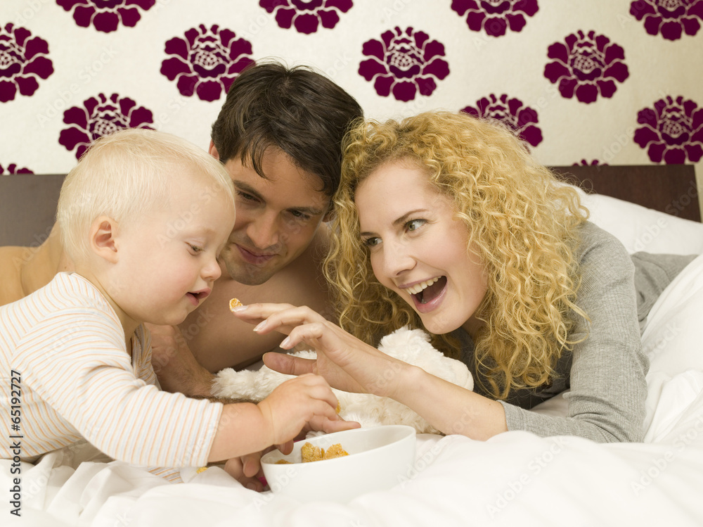 Eltern mit Baby ( 12-24 Monate) im Schlafzimmer Eltern mit Baby ( 12-24 Monate) im Schlafzimmer