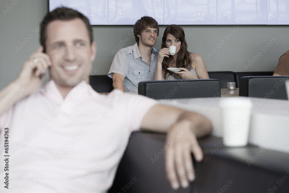 Fototapeta premium Deutschland,Köln,Paar im Café,Mann im Vordergrund mit Handy