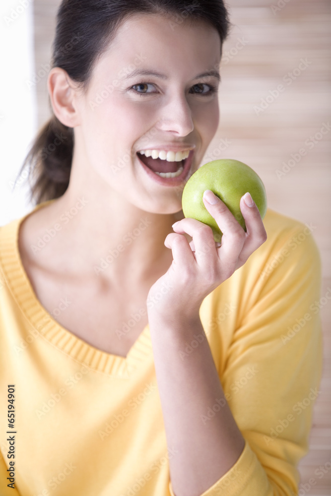 Junge Frau hält einen Apfel , Lächeln, Portrait Junge Frau hält einen Apfel , Lächeln, Portrait