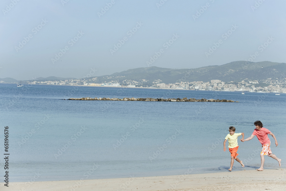 Spanien,Mallorca,Vater und Sohn ( 8-9) auf Strand laufen