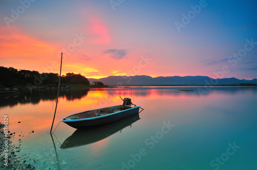 Lonely boat by the lakeside during beautiful sunset