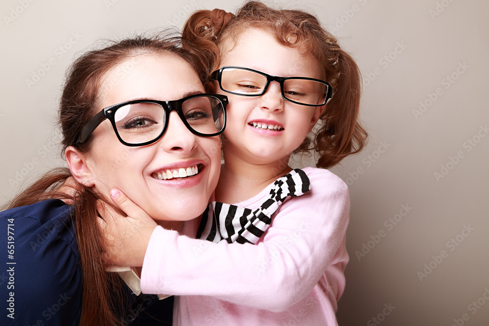 Happy young mother and lauging kid in fashion glasses hugging Happy young mother and lauging kid in fashion glasses hugging