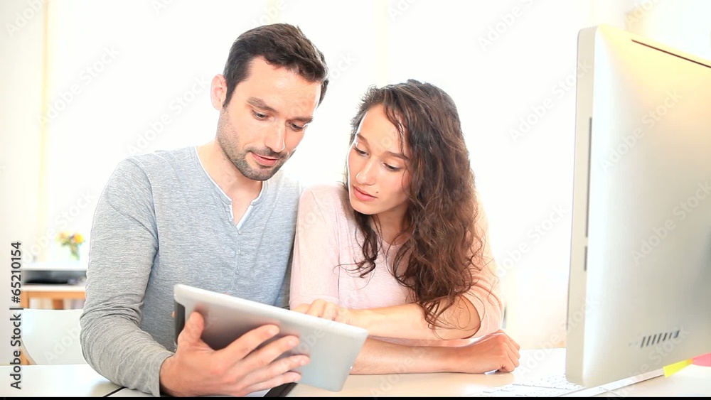 Man working on tablet with his co-worker Man working on tablet with his co-worker