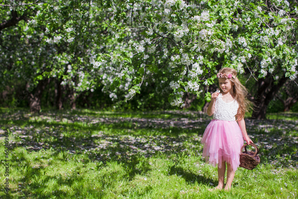 Adorable little girl with butterfly wings have fun in blossoming Adorable little girl with butterfly wings have fun in blossoming