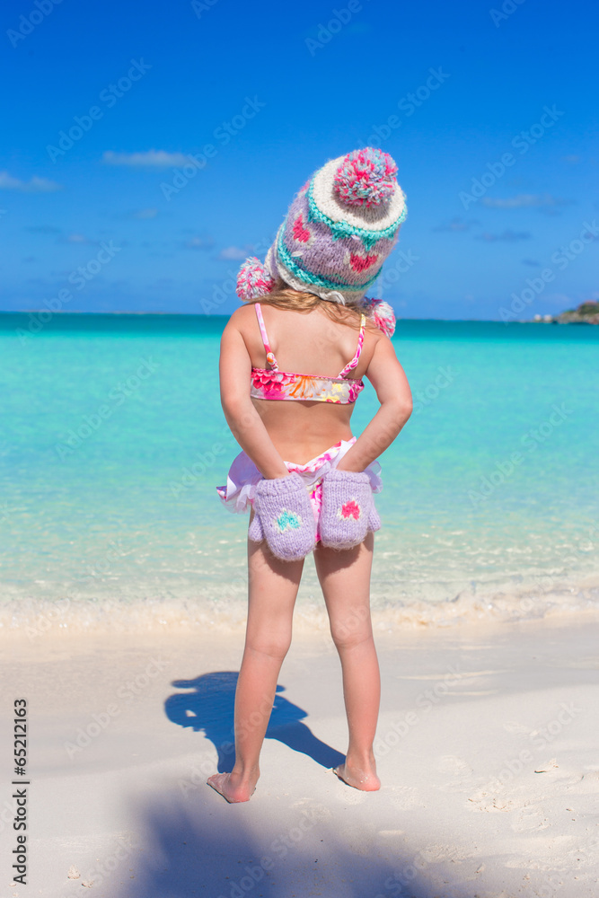 Back view of little adorable girl on tropical beach