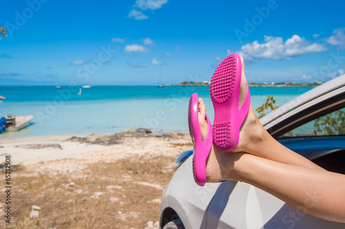 Flip Flops from the window of a car on background tropical beach © travnikovstudio