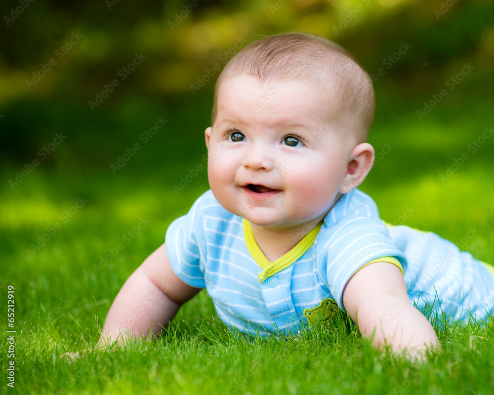 Spring portrait of happy baby boy outdoors on grass in field Spring portrait of happy baby boy outdoors on grass in field