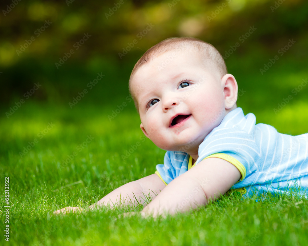 Spring portrait of happy baby boy outdoors on grass in field Spring portrait of happy baby boy outdoors on grass in field