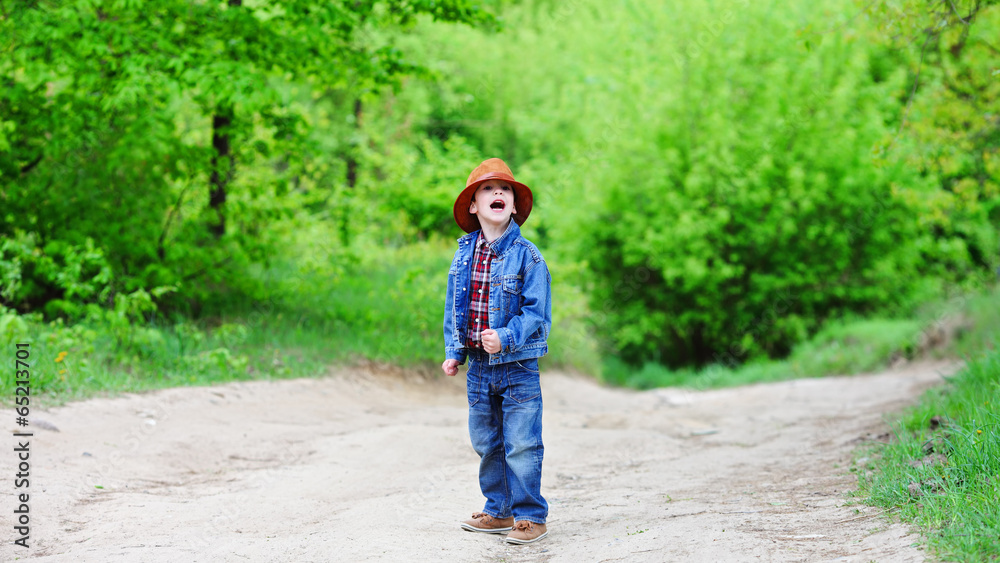 Happy smiling boy dressed in country style playing in the park Happy smiling boy dressed in country style playing in the park