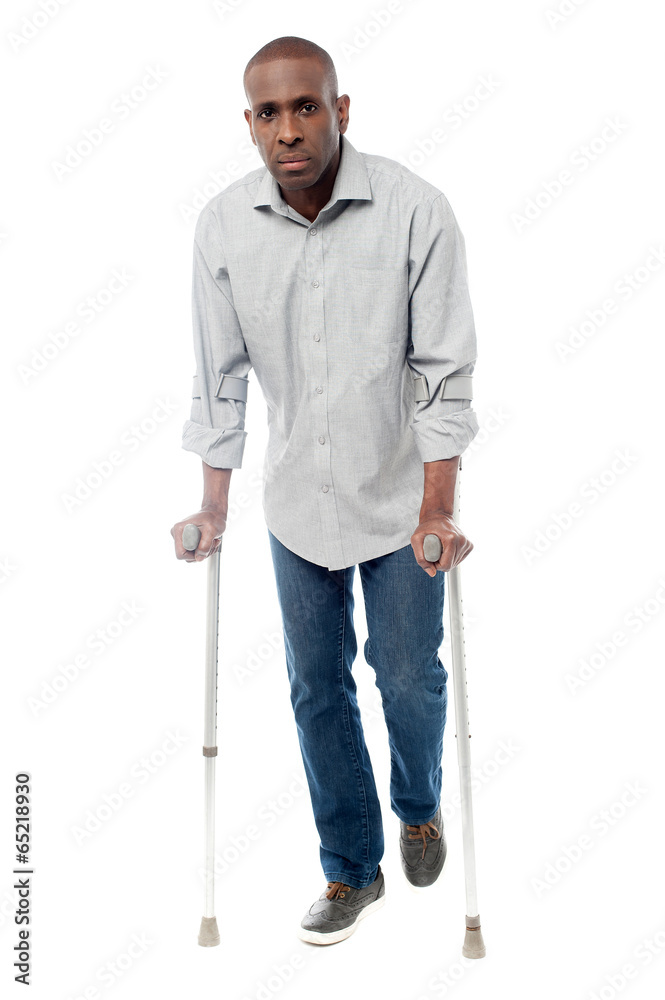 African man with crutches trying to walk African man with crutches trying to walk