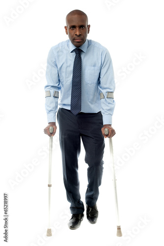 Canvas Print Middle aged man walking with two crutches