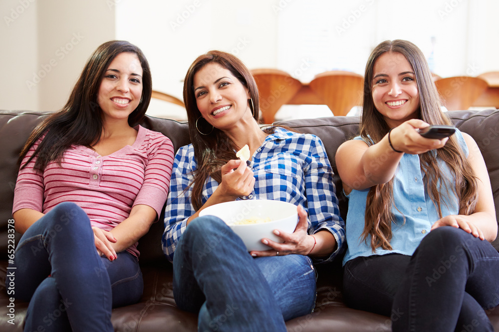 Group Of Women Sitting On Sofa Watching TV Together Group Of Women Sitting On Sofa Watching TV Together