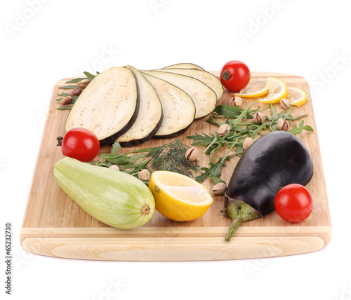 Vegetables with pistachios on wooden platter.