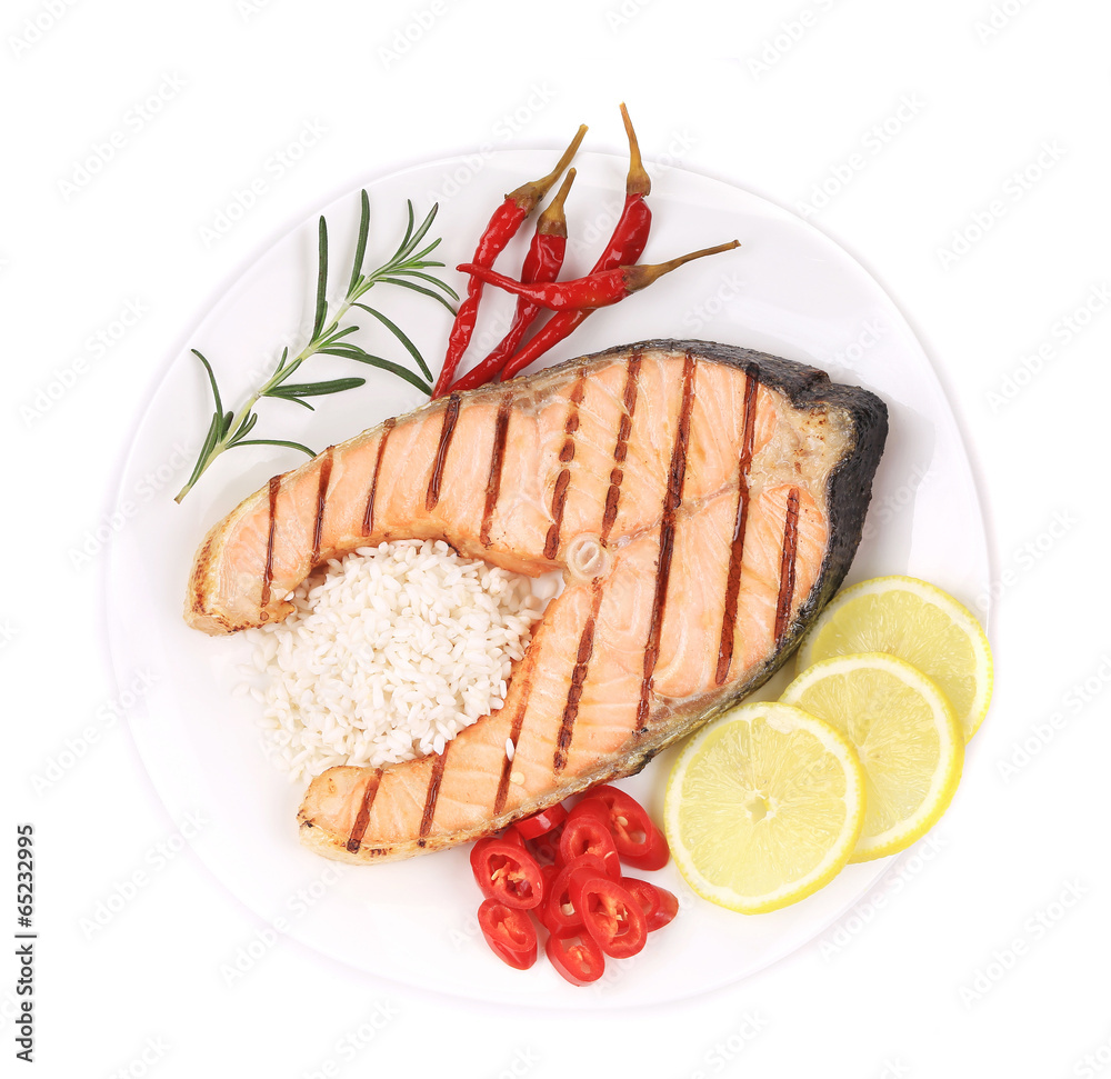 Grilled salmon steak with vegetables on plate.