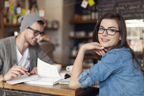 Stylish woman studying with her friend at cafe