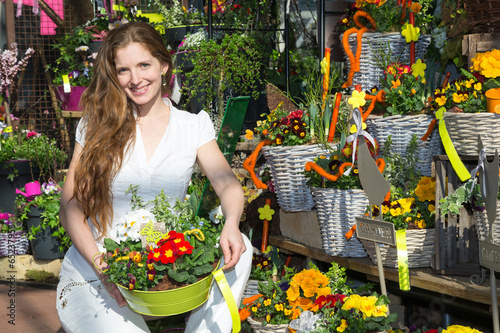 Kundin in Blumenladen mit Blumen und Gestecken photo