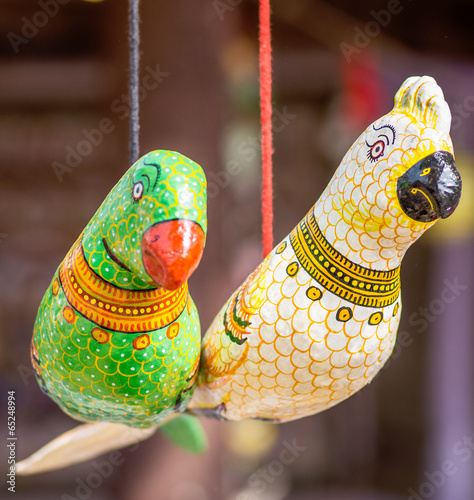 Toy parrots hanging on a thread photo