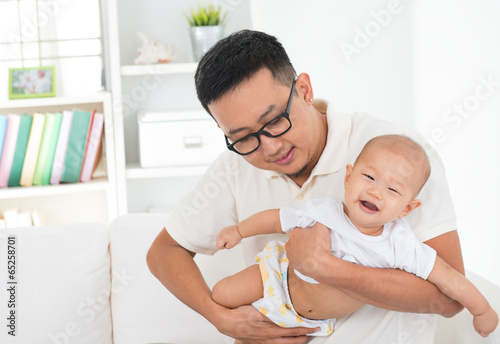 Asian family lifestyle at home. Father flying baby boy, having f