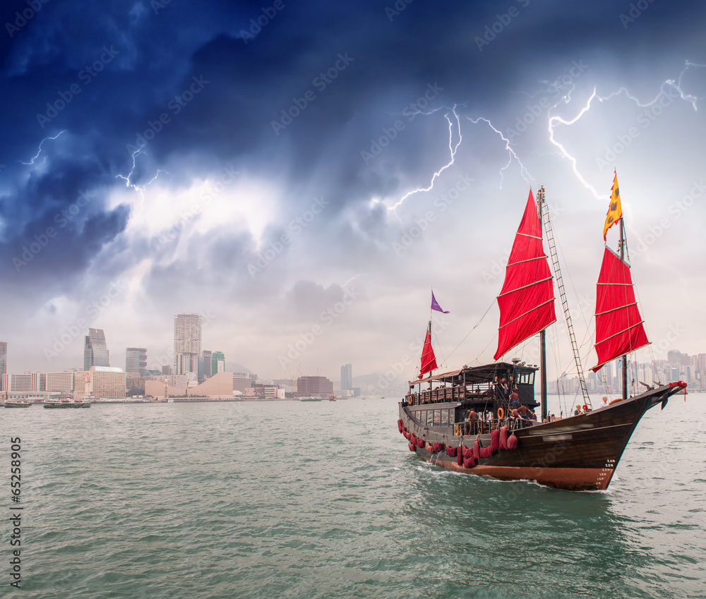 Fototapeta premium Sailing ship crossing the sea near a city during a storm