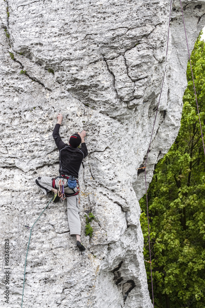  Man climbing limestone wall in Poland.