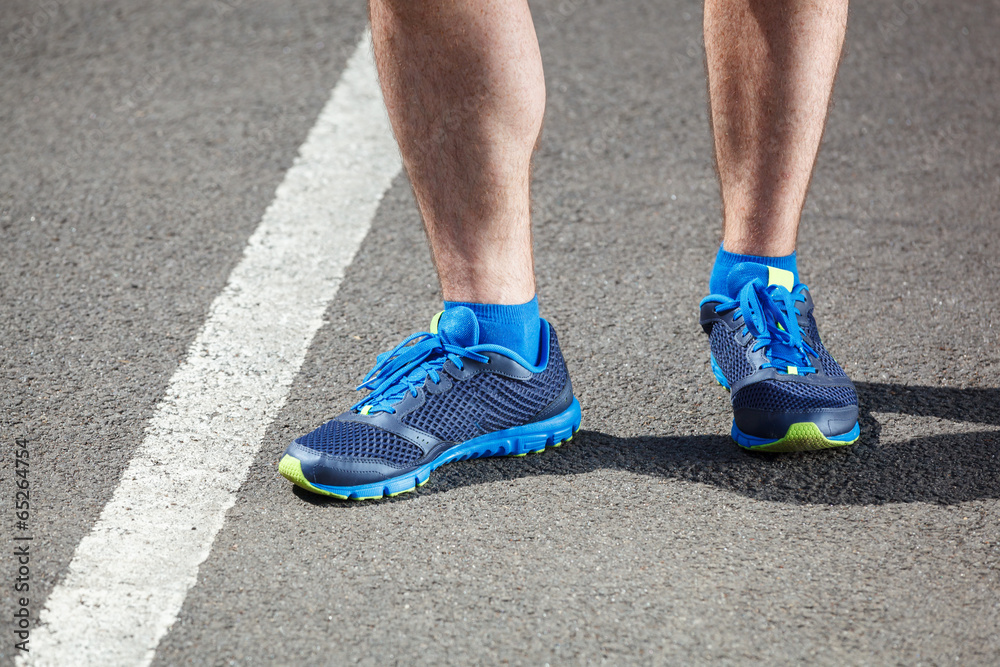 Closeup of a male runner standing - Fitness concept.