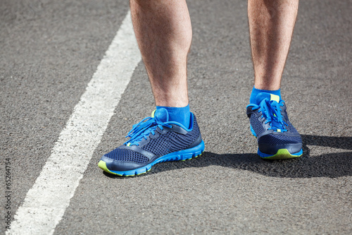 Closeup of a male runner standing - Fitness concept.