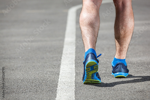 Runner feet running on stadium closeup on shoe.