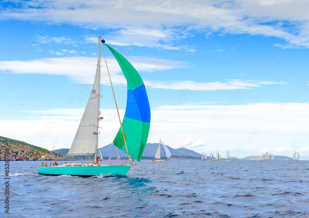 Naklejka premium Sailing boat with a green blue spinnaker Poros island Greece