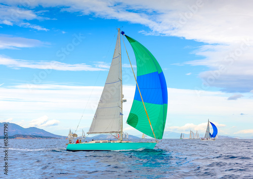 Sailing boat with a green blue spinnaker out of Poros in Greece