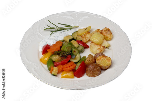 isolated plate with vegetables and oven potatoes