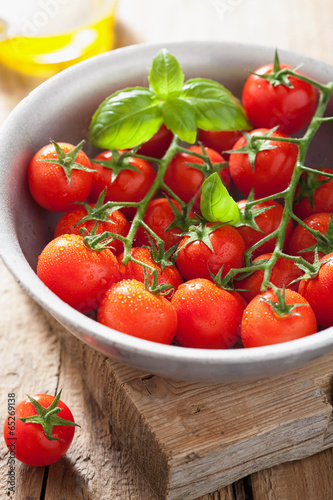 cherry tomatoes basil and olive oil over wooden background