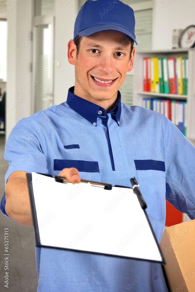Smiling delivery man, holding clip board and carton box Smiling delivery man, holding clip board and carton box