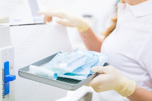Assistentin mit sterilen Zahnarzt Instrumenten  photo
