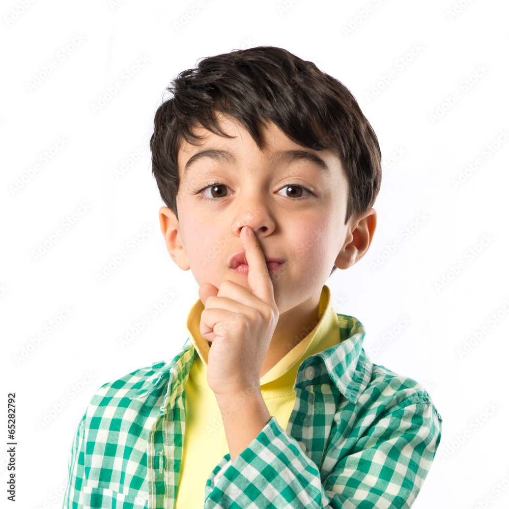 Kid doing silence gesture over white background Kid doing silence gesture over white background