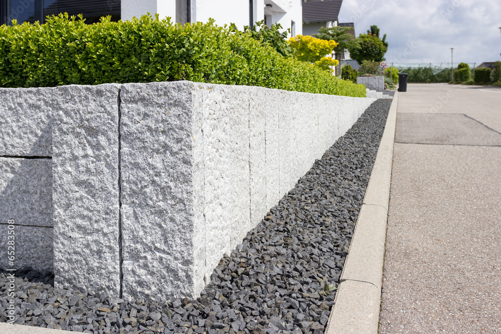 Neue Granitmauer im eigenen Garten StockFoto Adobe Stock