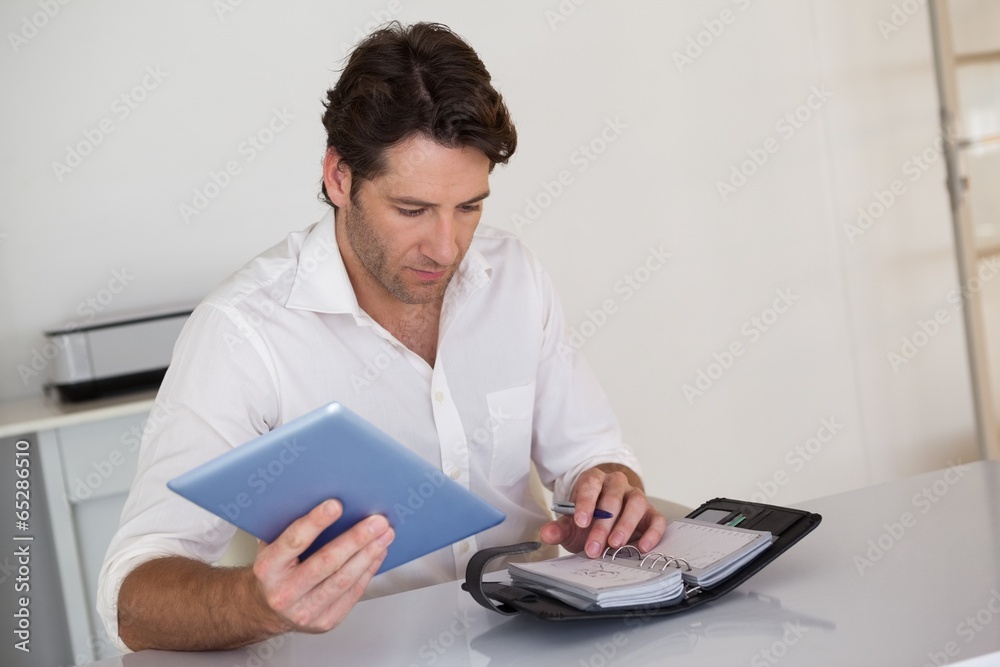Casual businessman organizing his schedule at his desk Casual businessman organizing his schedule at his desk