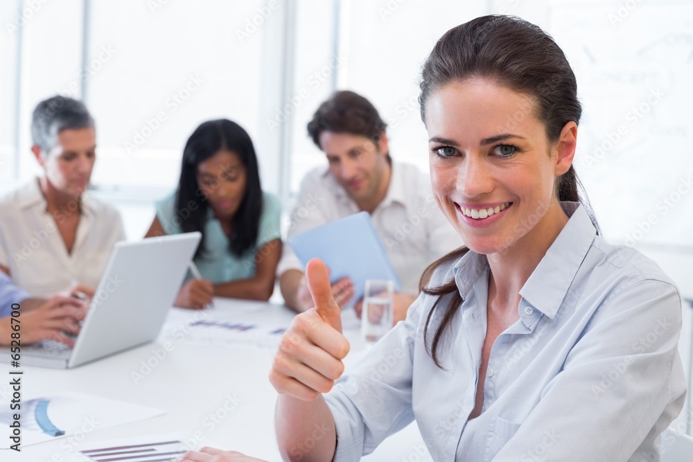 Attractive businesswoman giving the thumb of approval Attractive businesswoman giving the thumb of approval