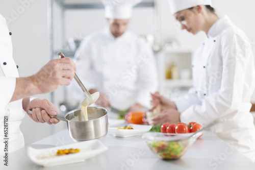 anonymous hands preparing food in professional kitchen