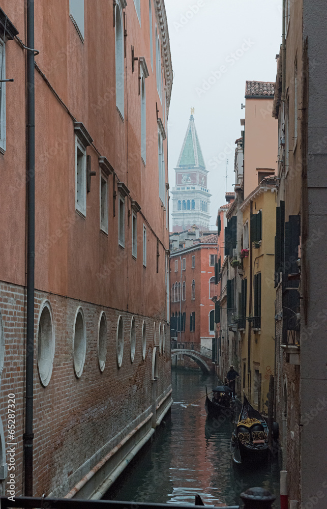 Narrow canal with gondolas in Venice, Italy.