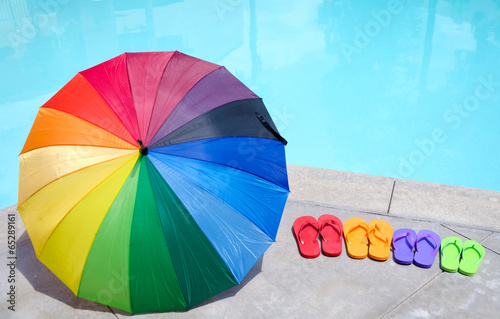 Color umbrella and flip flops by the pool