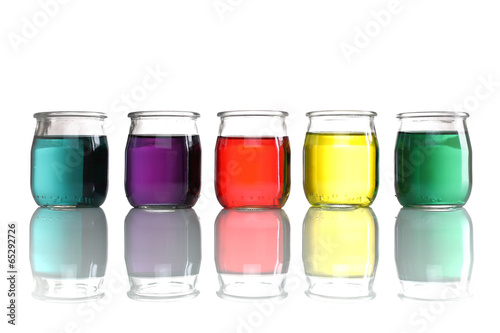 jars of colored water stacked on white background