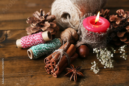 Composition with natural bump, candle, thread, cinnamon sticks