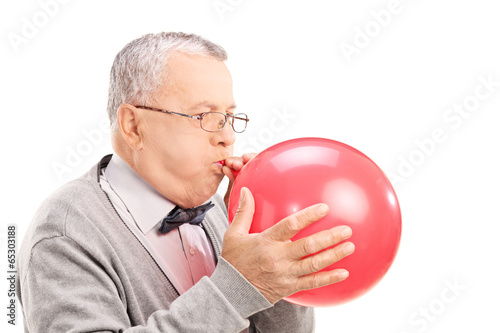 Valokuva Mature man blowing up a balloon