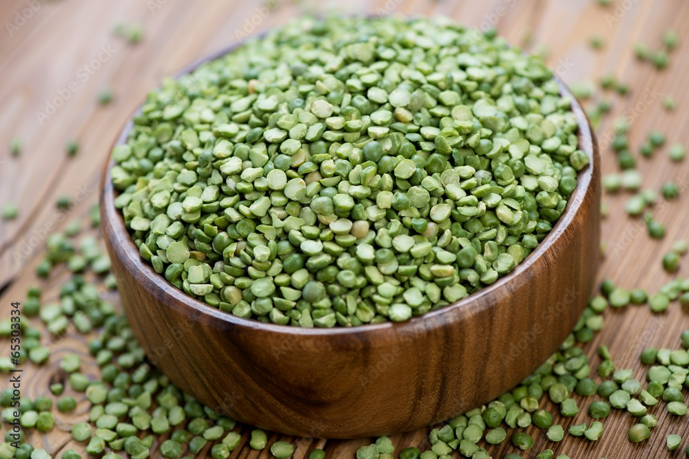 Wooden bowl with split dried green peas, horizontal shot Wooden bowl with split dried green peas, horizontal shot