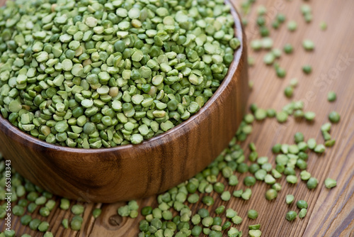 Split dried peas in a wooden bowl, close-up, studio shot